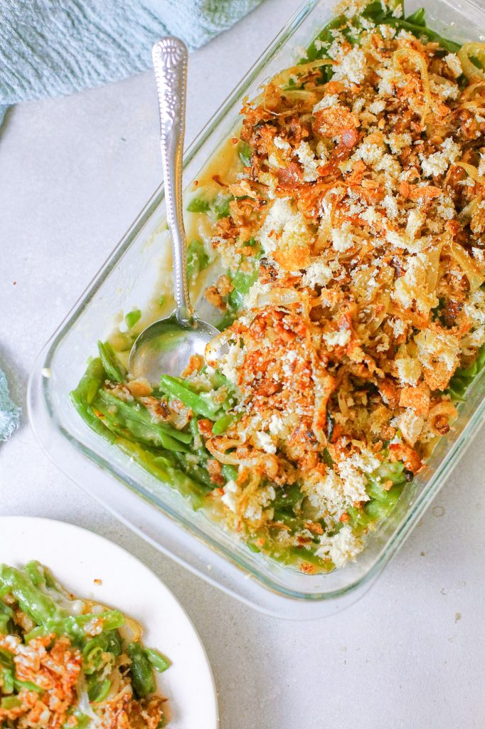 scoop of dairy free green bean casserole being taken out of casserole serving dish