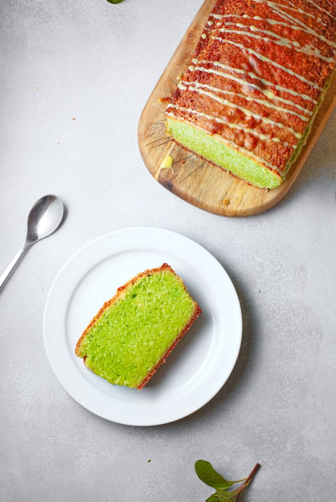 above a cut slice of vegan matcha cake with the loaf in the background 