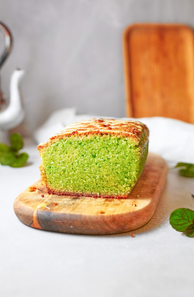side view of a loaf of vegan matcha pound cake with mint
