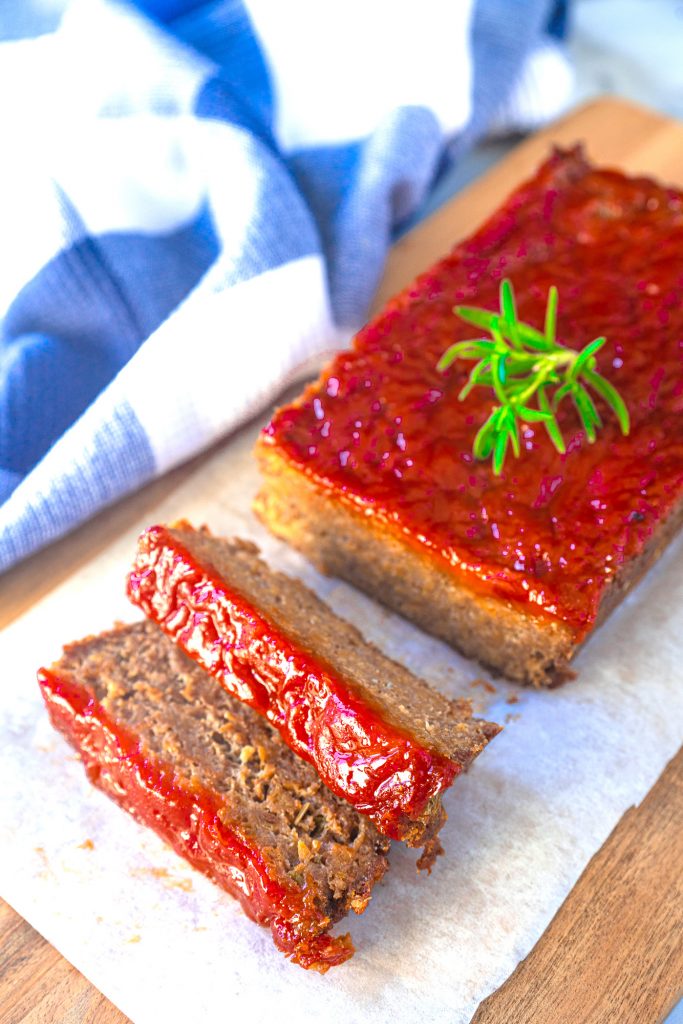 vegan meatloaf on serving tray with rosemary
