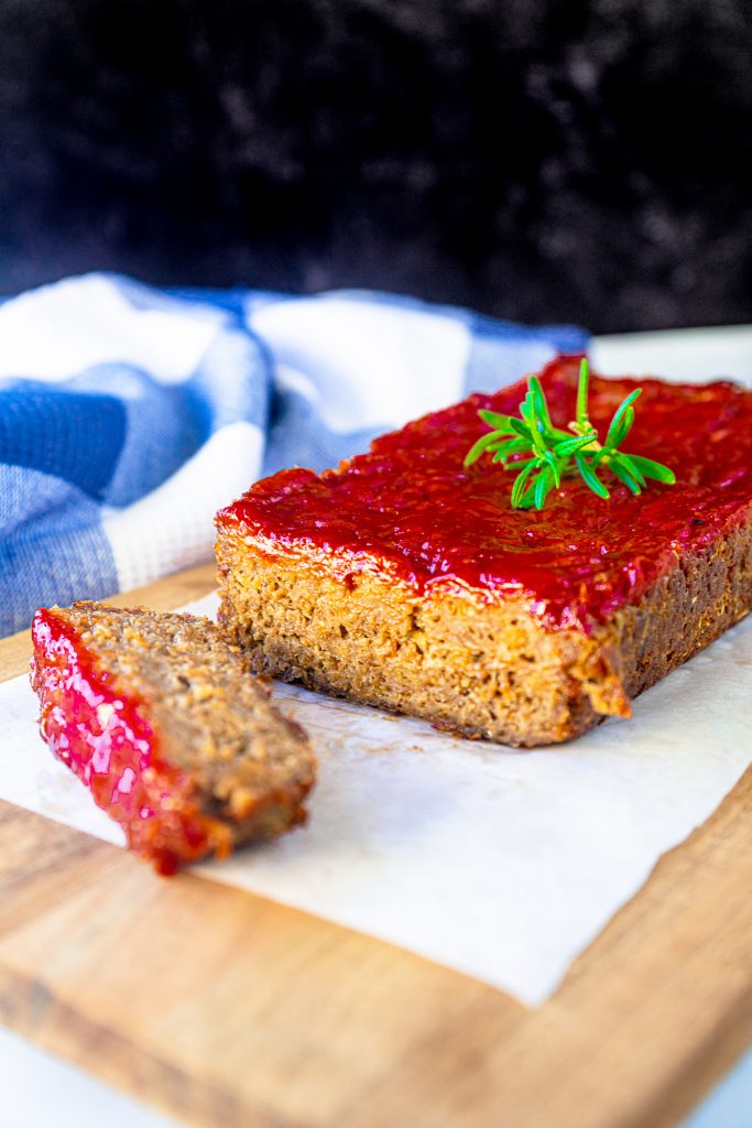 one slice of meatless meatloaf with red glaze on cutting board