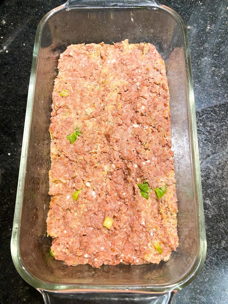 red vegan meat pushed into a baking dish 