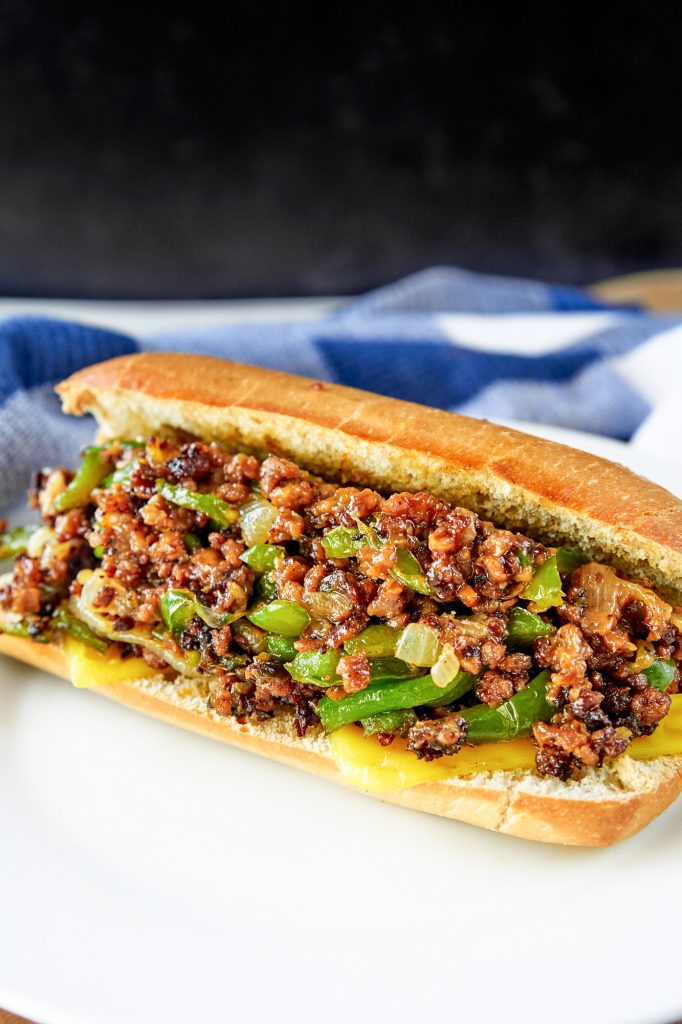 vegan philly cheesesteak on white plate with blue towel