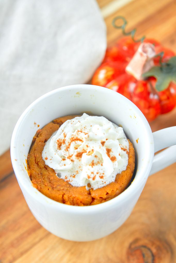 large scoop of whipped cream topping healthy pumpkin mug cake