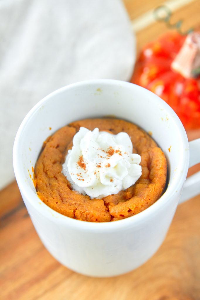 vegan pumpkin mug cake topped with whipped cream
