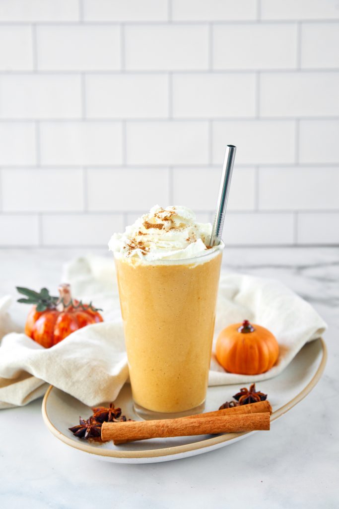 far away image of vegan pumpkin spice frappuccino with a metal straw