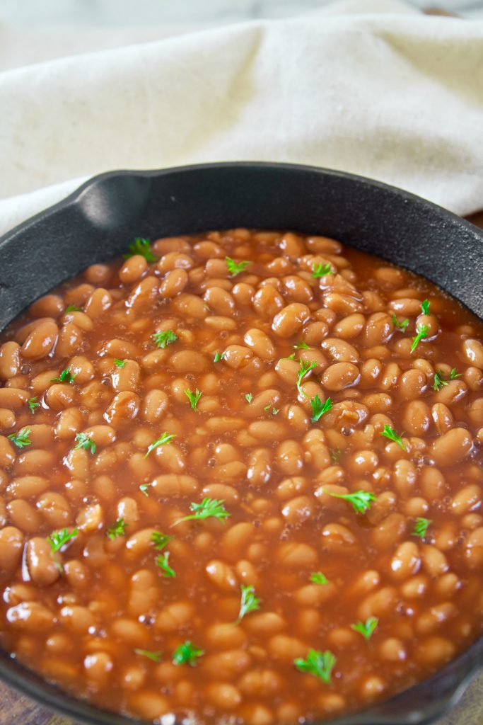 close up of vegan baked beans recipe in a cast iron skillet