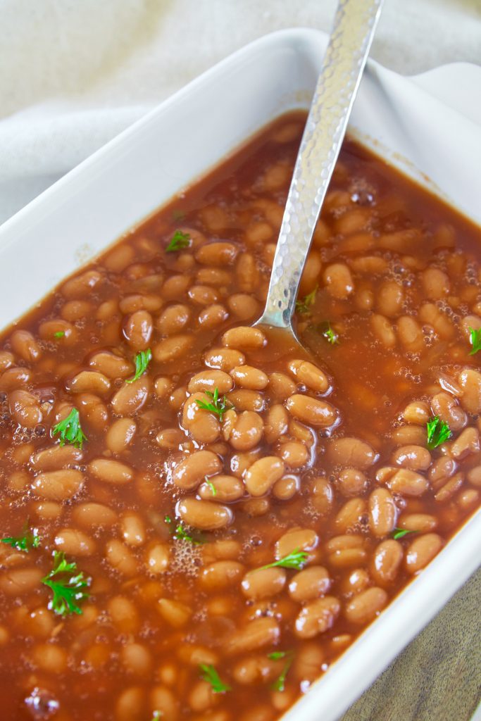 spoon in a dish of vegan baked beans 