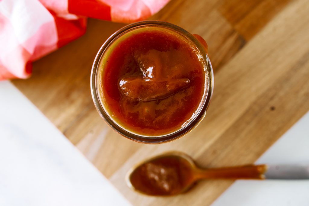 jar of vegan bbq sauce from above on a cutting board