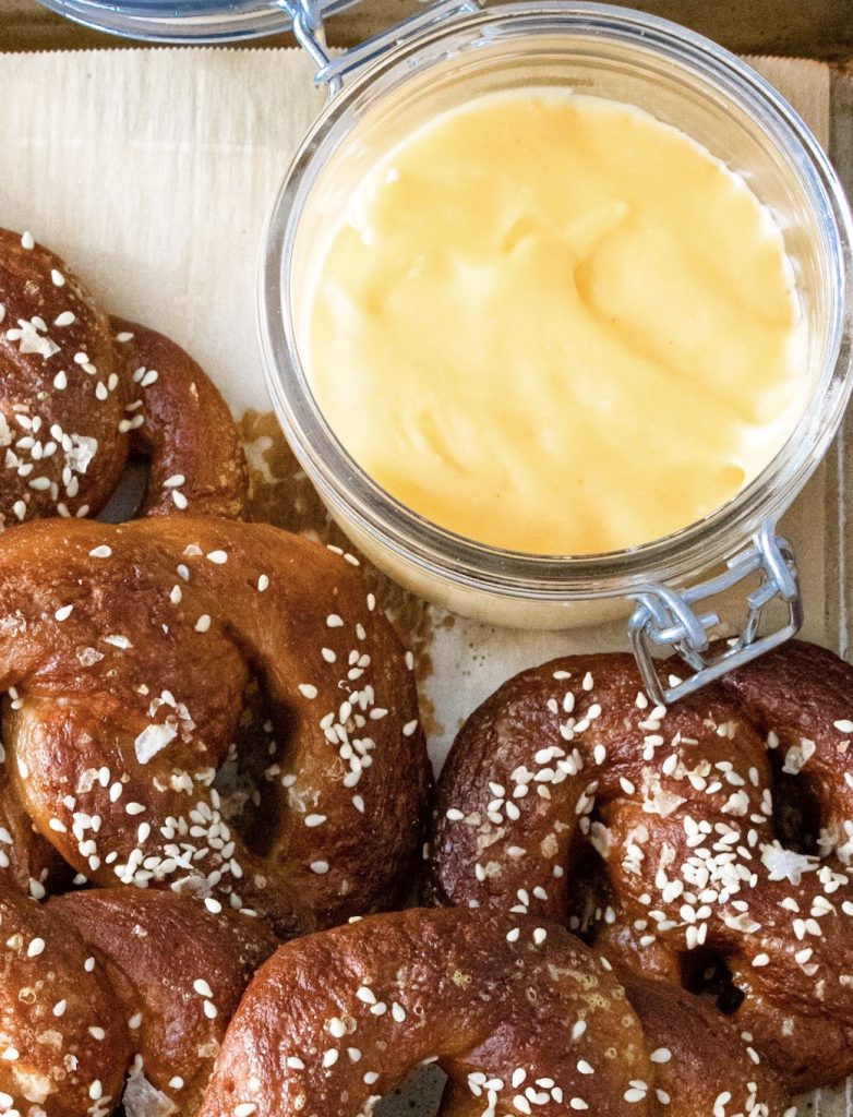 vegan beer cheese dip on serving tray with soft pretzels