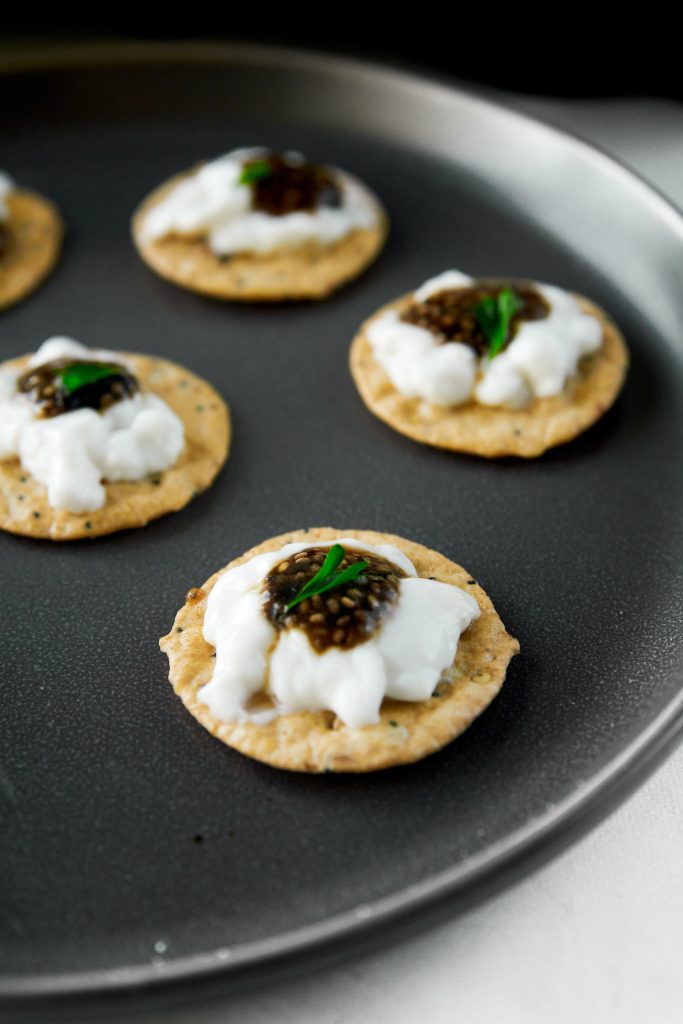 little crackers topped with sour cream and vegan caviar