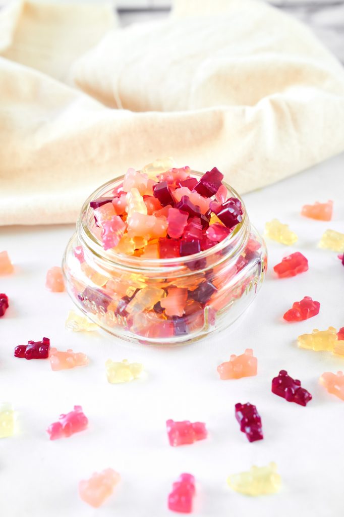 full vegan gummy bears recipe spilling out of a jar with some on the counter top