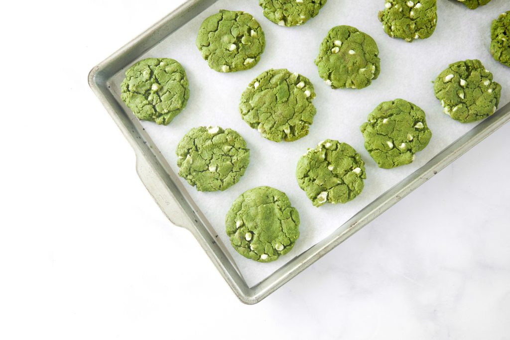 baking sheet with green tea cookies on it with white chocolate chips