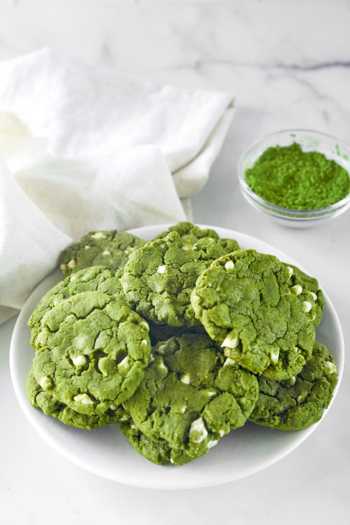 plate of vegan matcha cookies with matcha powder in the background