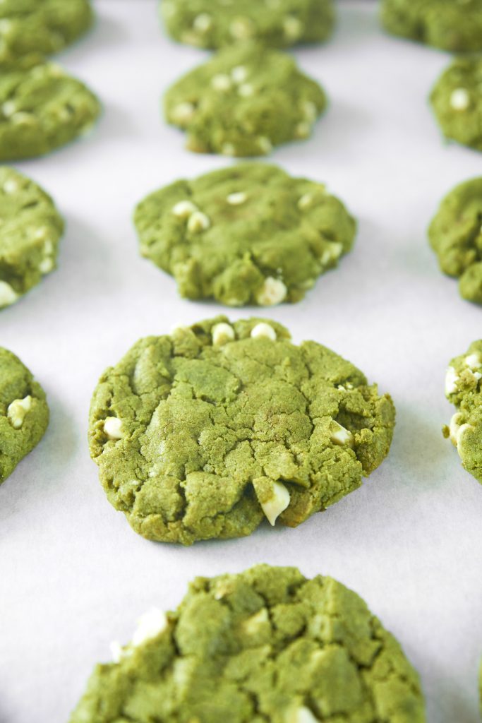 vegan matcha cookies with white chocolate chips on baking tray
