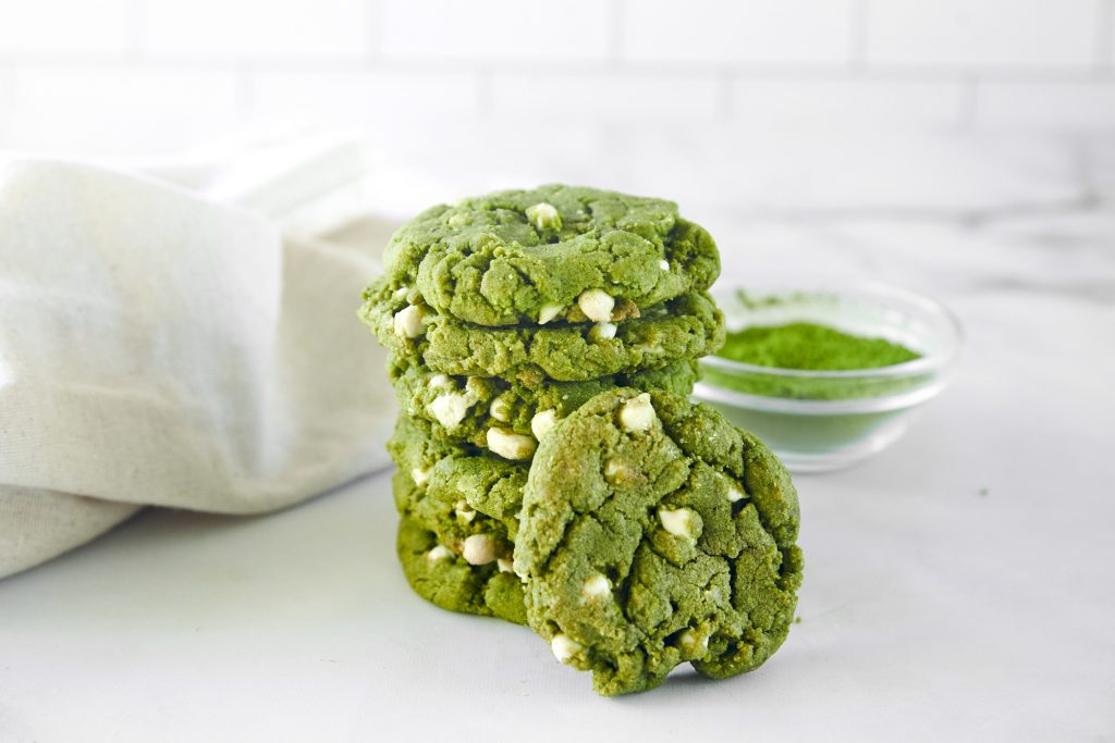 vegan green tea cookies stacked with matcha powder in the background