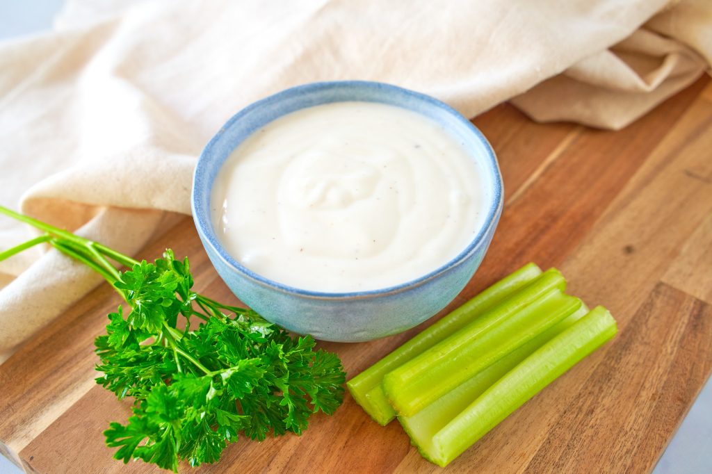 non dairy ranch dressing in a bowl with celery and parsley