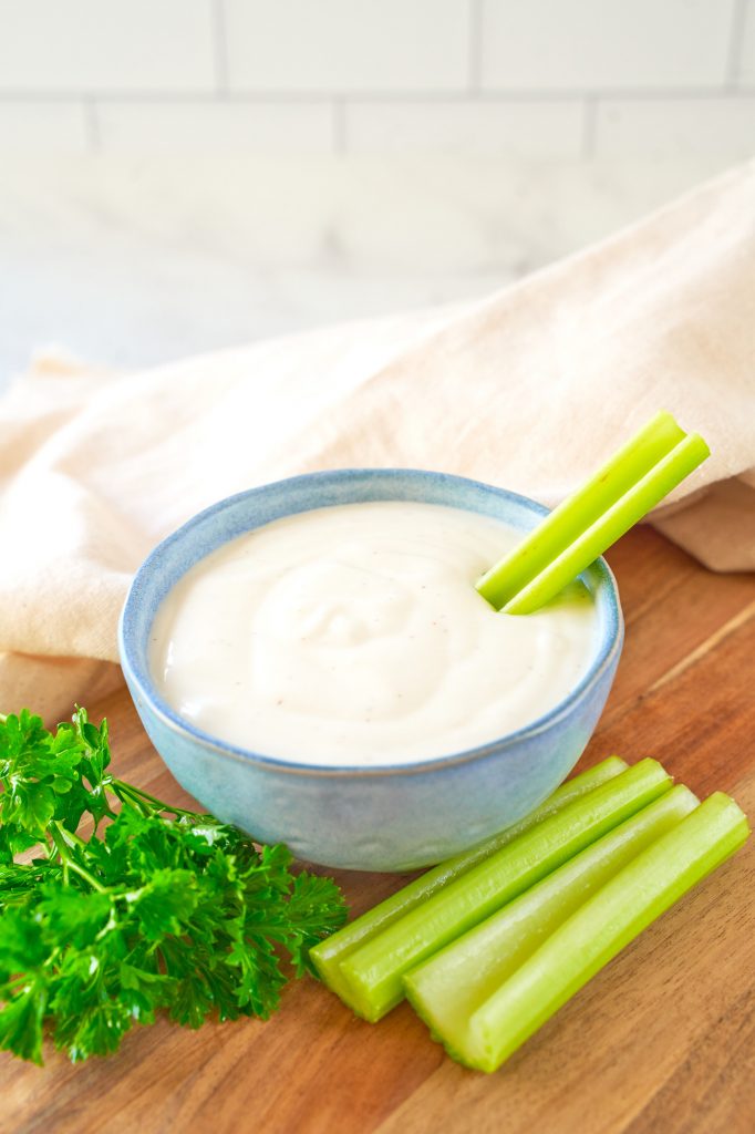 celery and parsley with vegan ranch dip in a bowl
