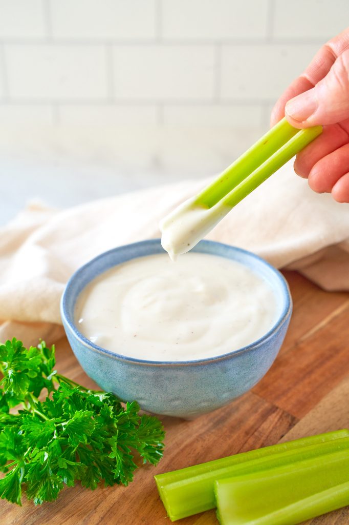 vegan ranch dip being scooped up with a piece of celery
