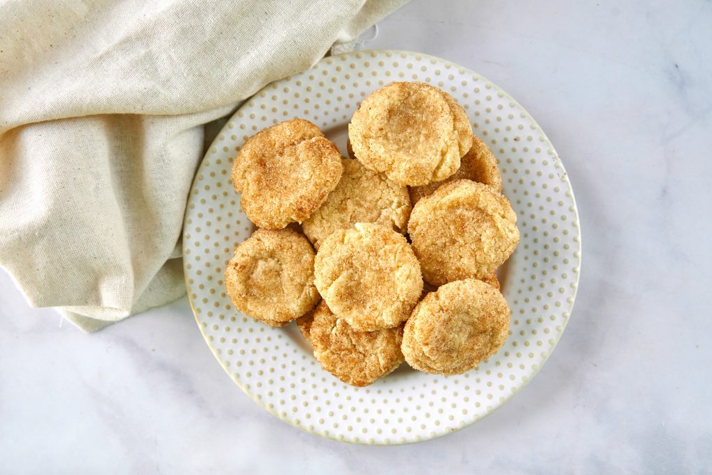 plate of vegan cinnamon cookies from above with brown dish towel on the side