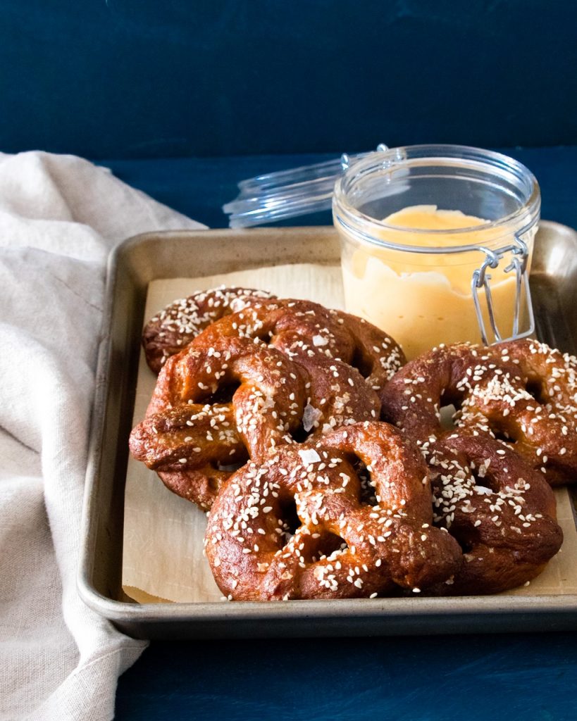 vegan soft pretzels with vegan beer cheese on baking tray