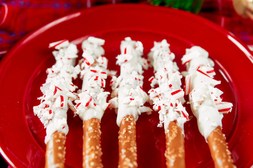 close up on christmas pretzels rolled in crushed candy canes on a red plate