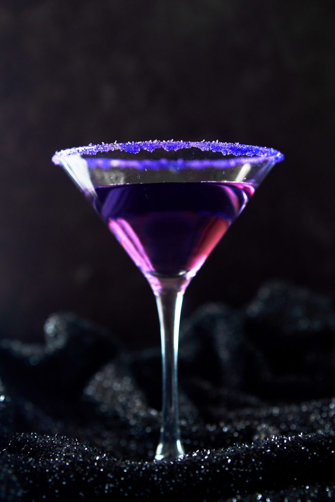 purple Halloween cocktail with purple sanding sugar