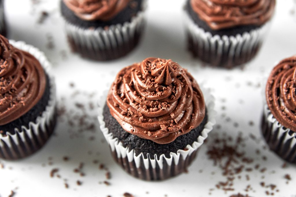 vegan chocolate cupcakes from above with chocolate shavings all around.