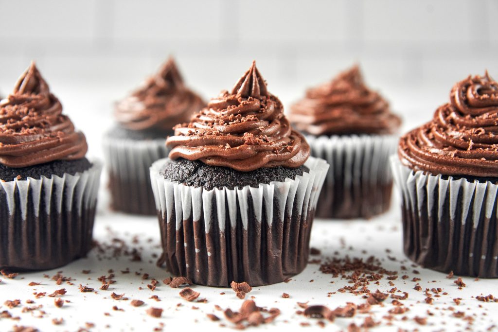 vegan chocolate cupcakes with chocolate icing and shavings