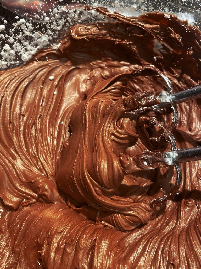 vegan chocolate frosting being made in a bowl