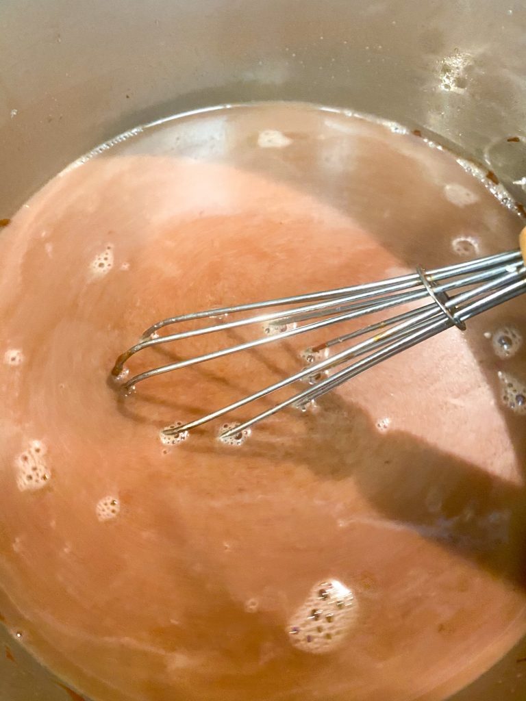 whisk in a container of vegan hot cocoa