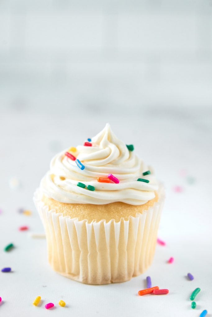 single vegan vanilla cupcake with sprinkles