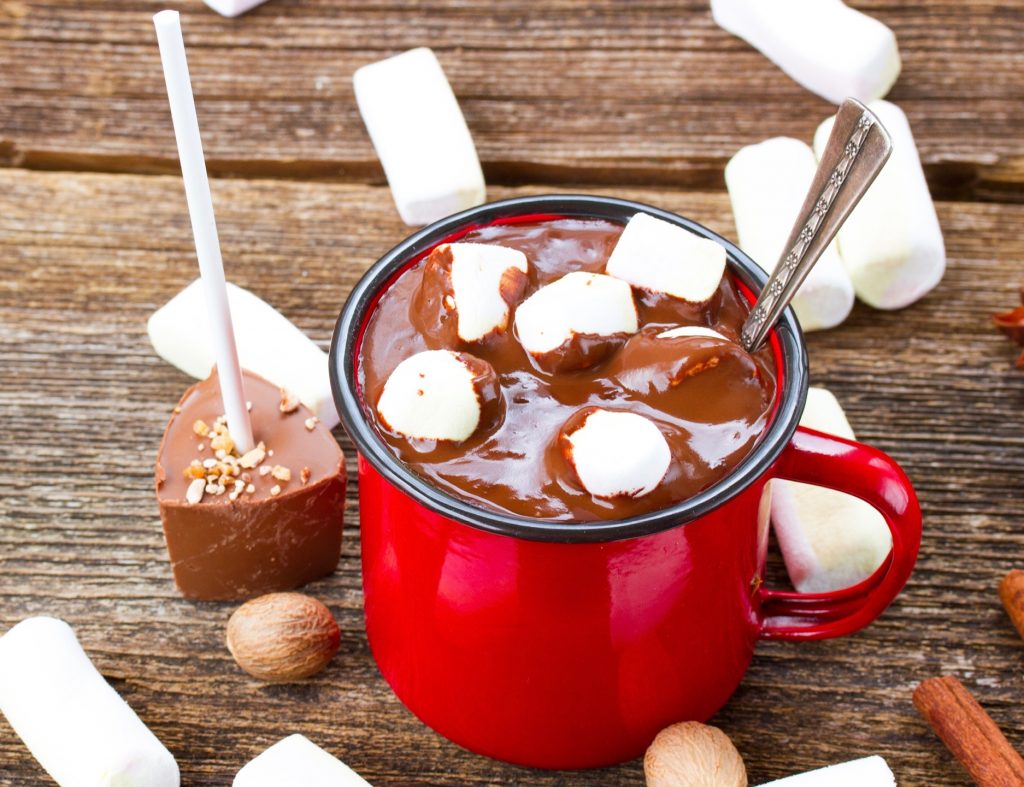 vegan hot chocolate on a stick near a red mug