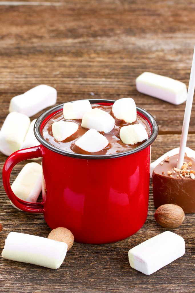 hot chocolate sticks with a red cup of liquid and marshmallows