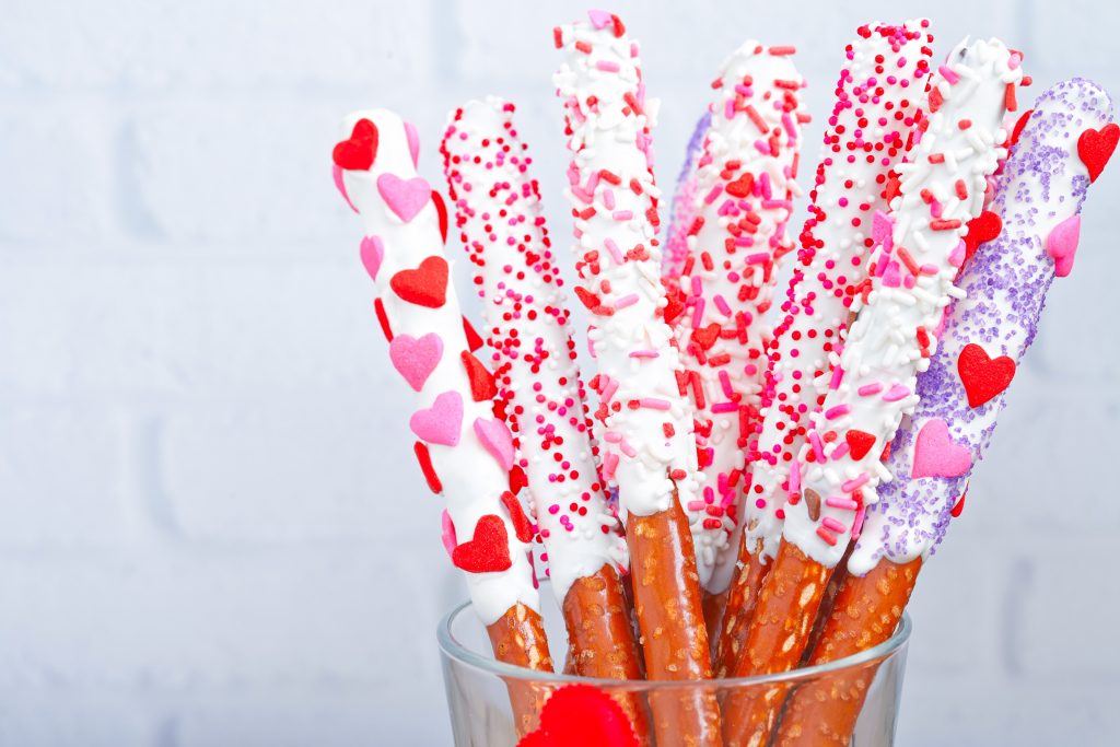 a group of valentines day pretzels in a jar dipped in white chocolate