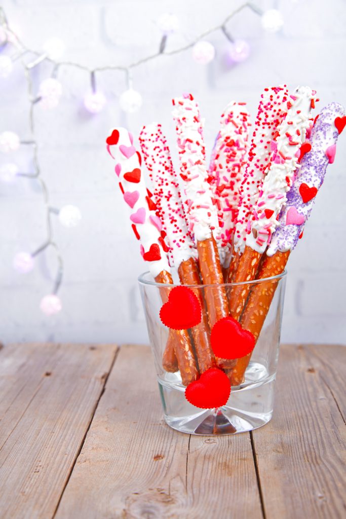 valentines day pretzel rods in a jar on a brown background