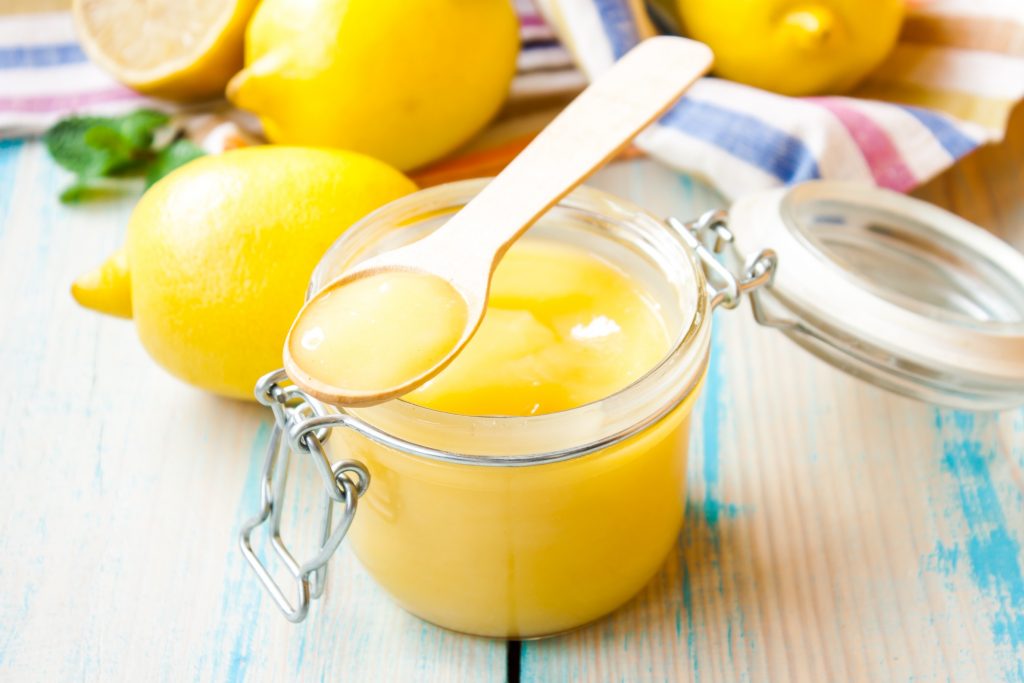 vegan lemon curd in a jar on a little spoon