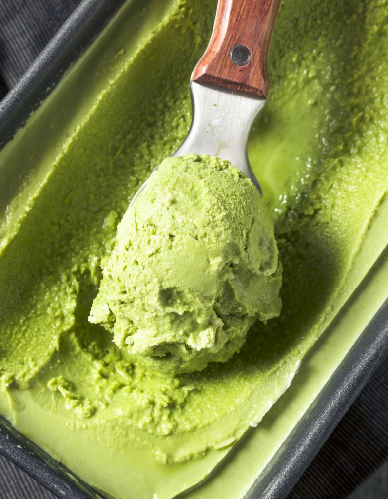 vegan matcha ice cream in a container with a scoop