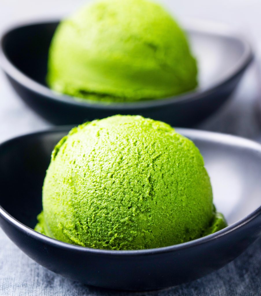 two scoops of non-dairy green tea ice cream in black bowls
