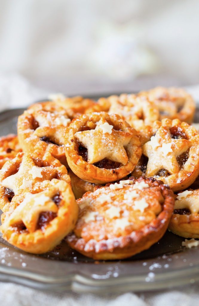 browned vegan mince pies with star shapes on them in a basket 