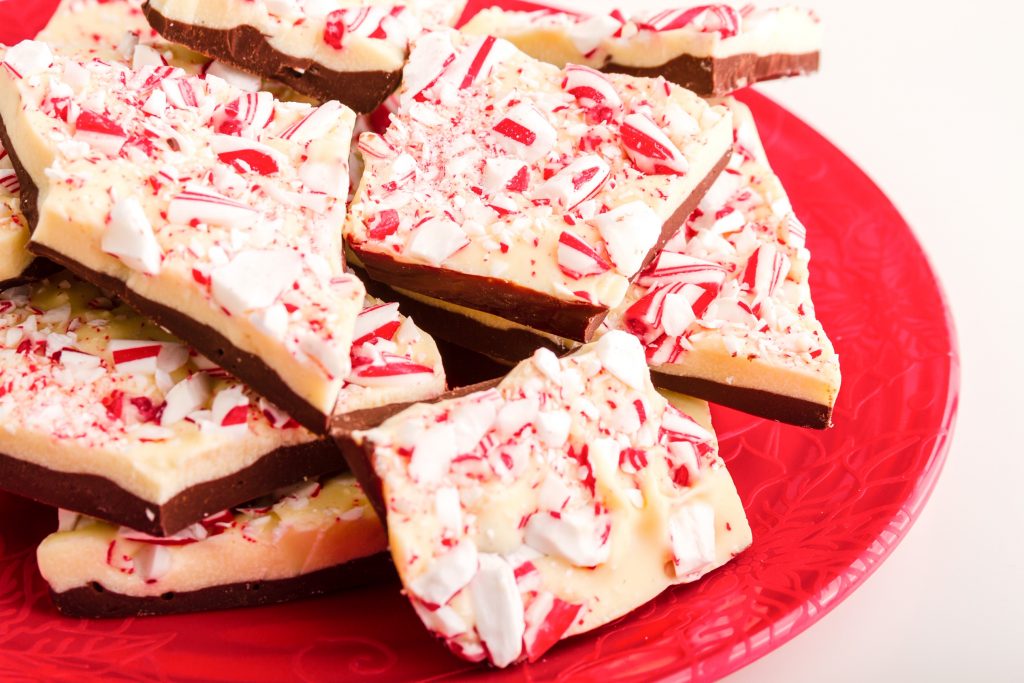 close up of vegan peppermint bark with white chocolate on a red plate