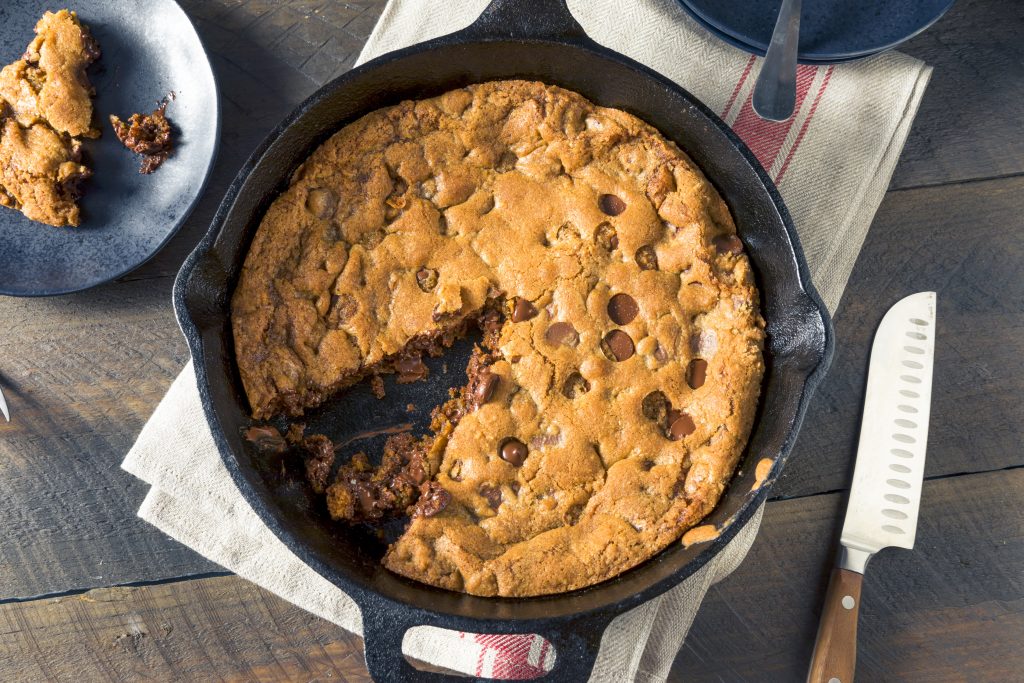 vegan skillet cookie with a slice taken out of it as seen from above on a table