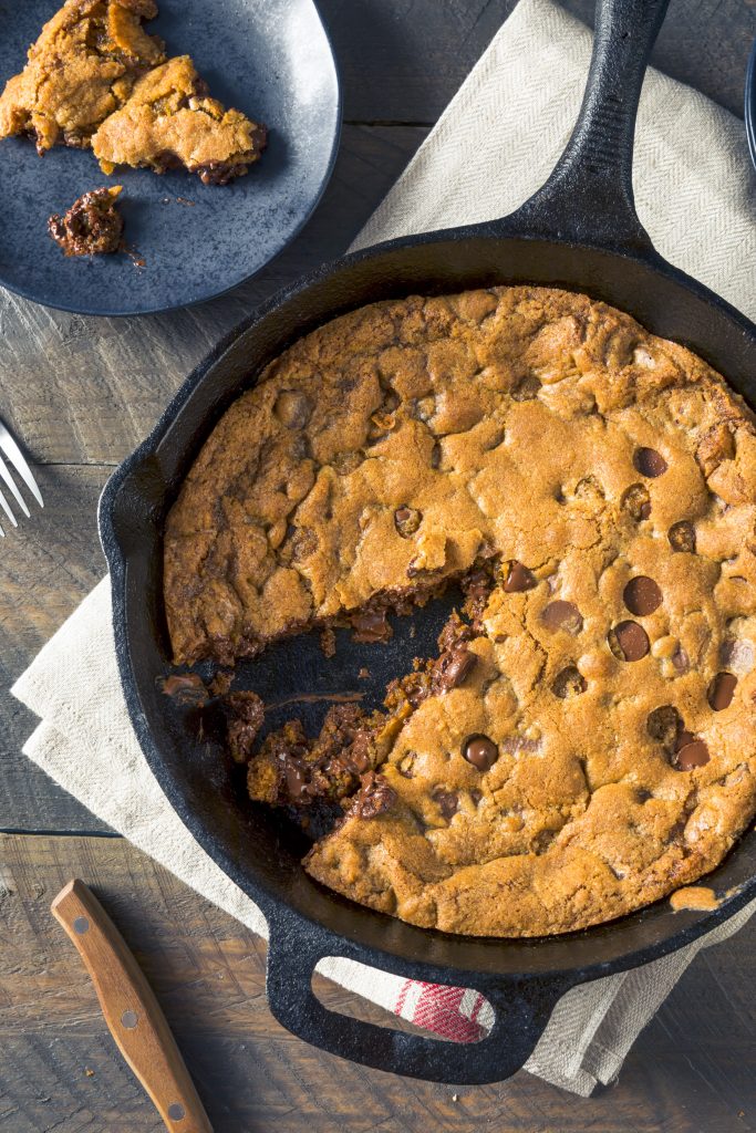 vegan skillet cookie with a slice being taken out of it