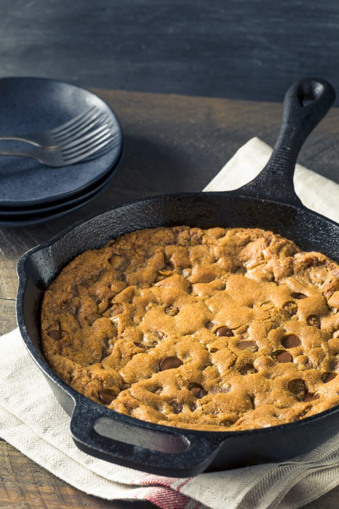 vegan skillet cookie not cut being baked in a cast iron pan