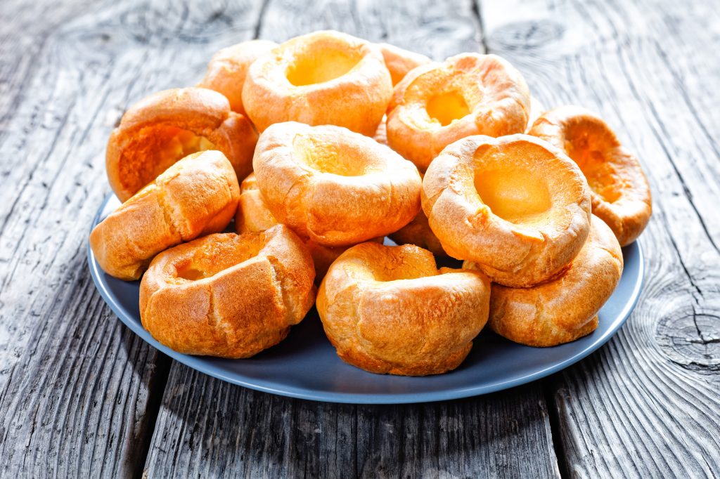 vegan yorkshire puddings stacked on a blue plate 