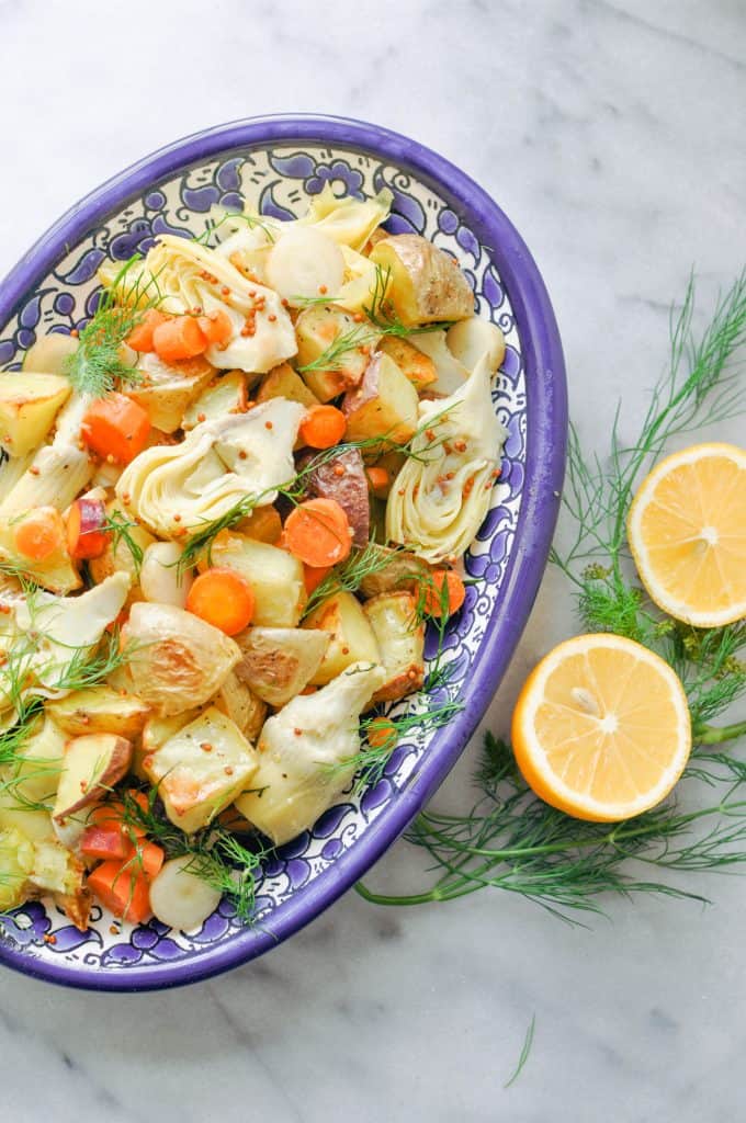 Photo of Artichoke Potato Salad With Dill being served in a blue and white bowl. 