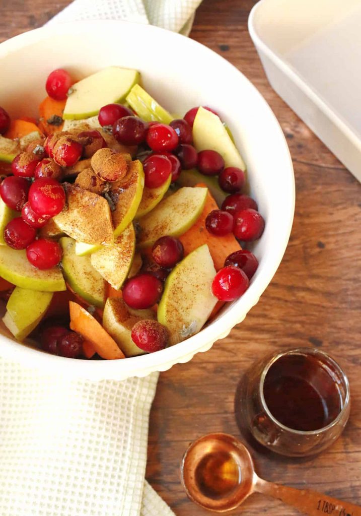 Photo of potatoes, apples, and cranberries in a bowl being prepared for a casserole.