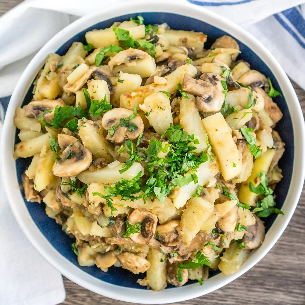 Photo of Sautéed Potatoes with Mushrooms being served in a white round bowl.