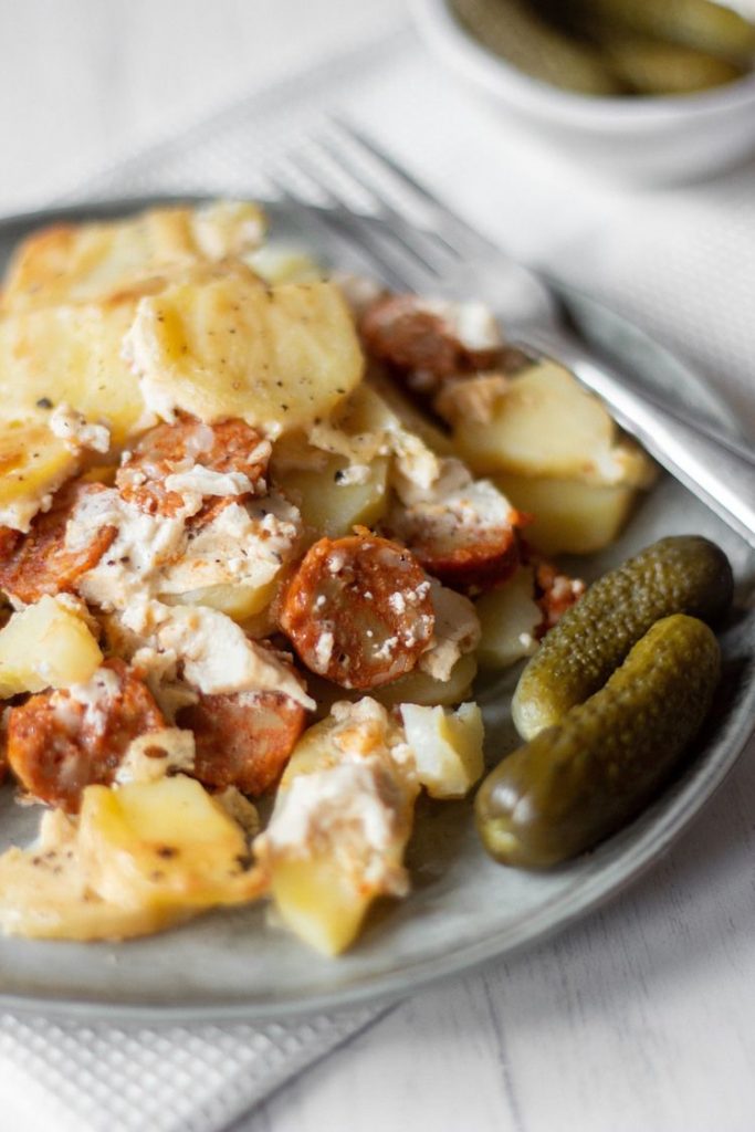 Photo of The Perfect Vegan Scalloped Potatoes being served with pickles. 