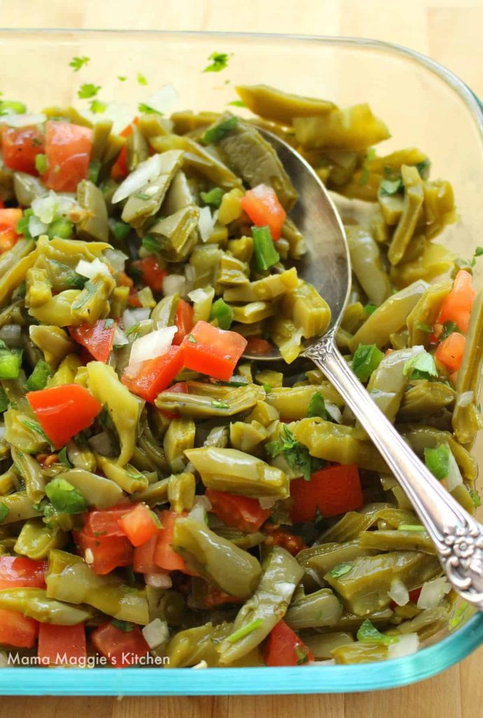 Photo of Ensalada de Nopales (Cactus Salad) being served in a glass dish.